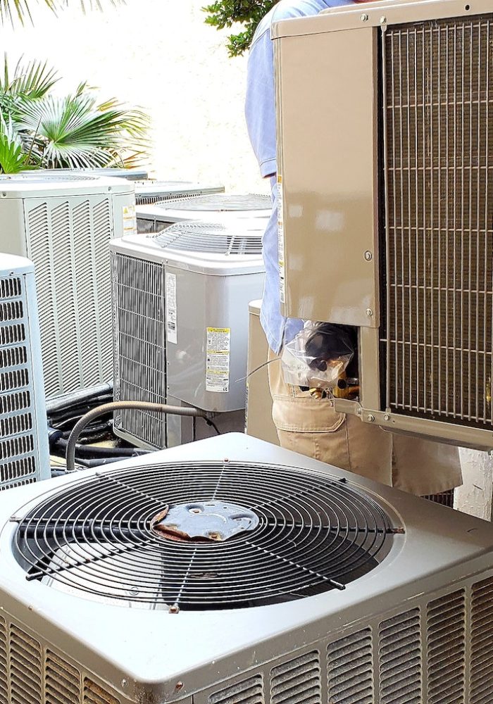 hvac technician removing old rusted broken airconditioners in HVAC at beach condo.